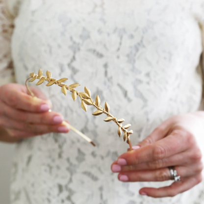 Model holding a gold bridal hair piece