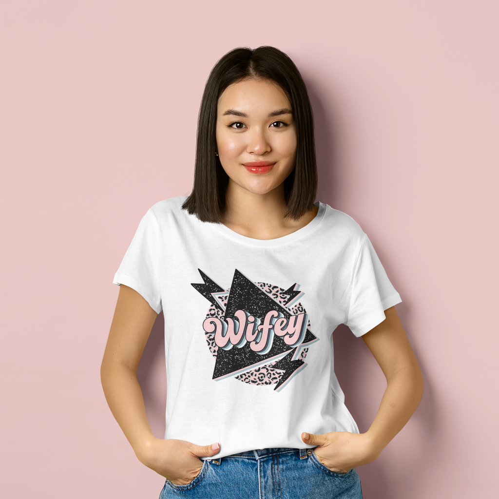 Young woman wearing a white t shirt with "wifey" printed in retro style writing and art.