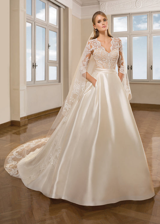 Woman wearing a satin ball gown with lace long sleeves front view