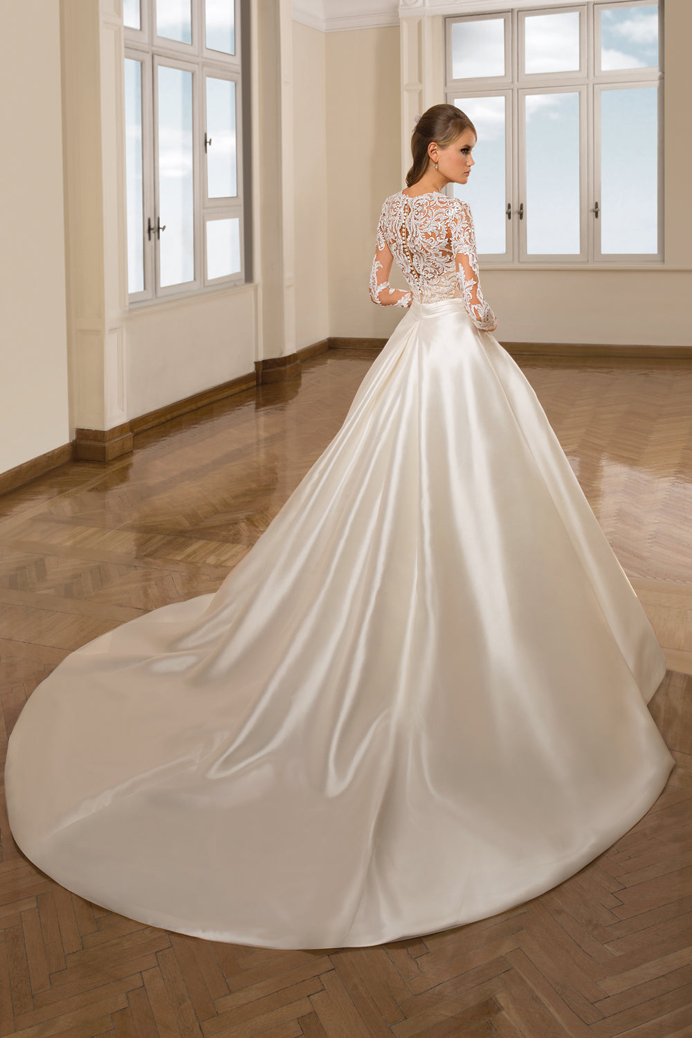 Woman wearing a satin ball gown with lace long sleeves back view